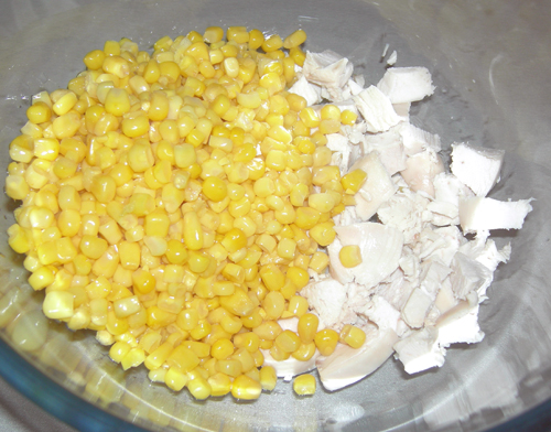 Грудки нарезаем небольшими кусочками, добавляем кукурузу, предварительно слив жидкость.