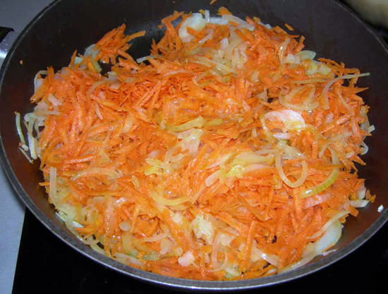 Морковь натереть на терке, лук порезать полукольцами, все посолить и обжарить овощи в растительном масле в течение 5–7 минут до золотистого цвета.