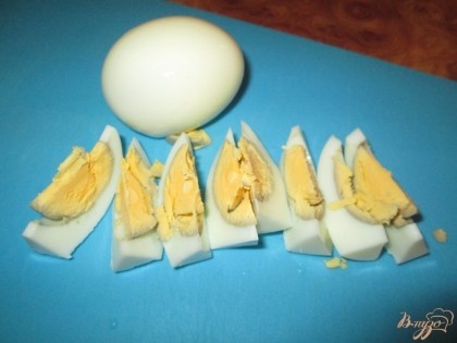 Отварить куриные яйца вкрутую и порезать крупными дольками.