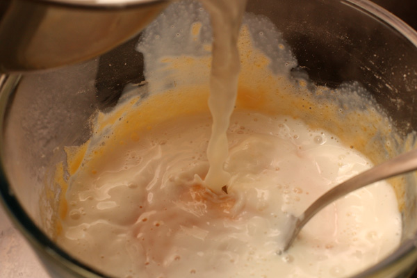 500 мл молока нагреваем с 50 г сахара. Как только молоко начнет закипать — выливаем его в желтки и хорошо перемешиваем.