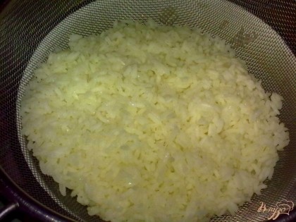 Рис отварить до полуготовности. Выложить на сито и дать стечь воде.