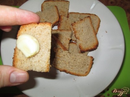 Пару зубчиков чеснока разрезать на половинки и натереть подсушенный хлеб с обеих сторон.