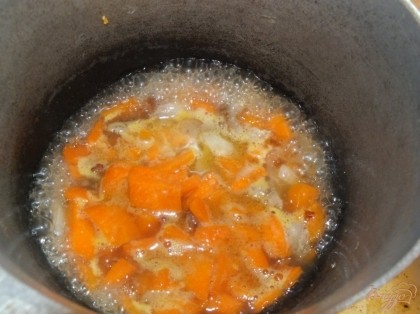 Нагреваем в казанке сало, топим. Обжариваем на нем лук и морковь. Добавляем 100 мл воды. Кладем кабачок.