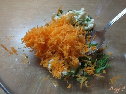 Морковь чистим и тщательно моем после чего натираем на мелкой терке. Смешиваем овощи и зелень в салатнике.