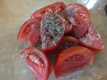 В салатник сложите помидор и посыпьте его травами.