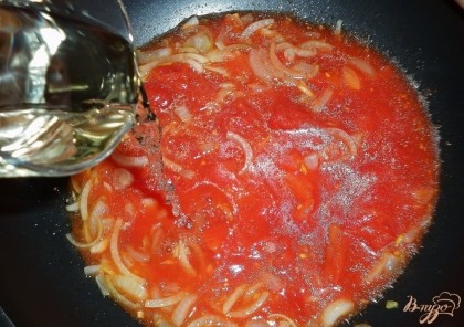 Добавить измельченные томаты в собственном соку и вино. Посолить, накрыть крышкой, тушить 15 мин.