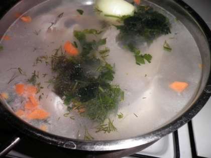 В кастрюлю налить воду, добавить луковицу, нарезанные морковь и зелень, положить рыбу и картофель. Посолить
