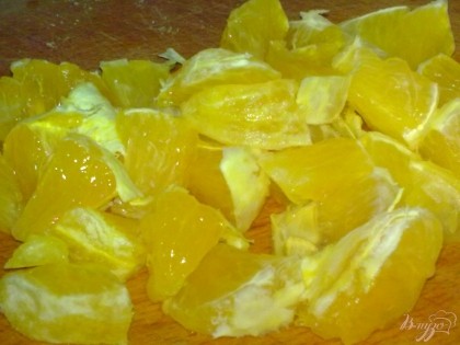 Апельсин очистите и нарежьте на кусочки.