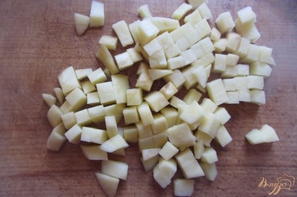 Картофель отчистить от кожуры, тщательно промыть, нарезать мелкими кубиками. добавить в суп, помешать. Варить на медленном огне.