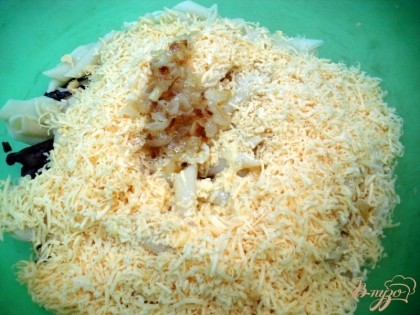 На макароны с грибами выложите сыр, яйца и половину пассерованного лука.