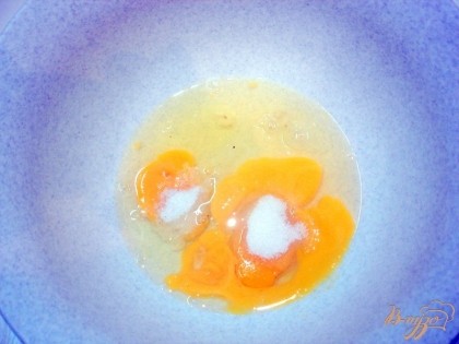 К яйцам добавляем столовую ложку сахара и чайную ложку соли и хорошо разбалтываем вилкой.