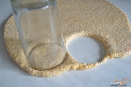 Из теста раскатать пласт толщиной 0.5-0.7 см. Вырезать стаканом (формочкой) печенья.