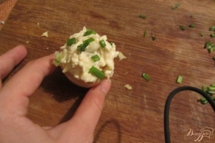 Выкладываем салат с помощью чайной ложки в тарталетки. Посыпаем мелко нарезанным зеленным луком.