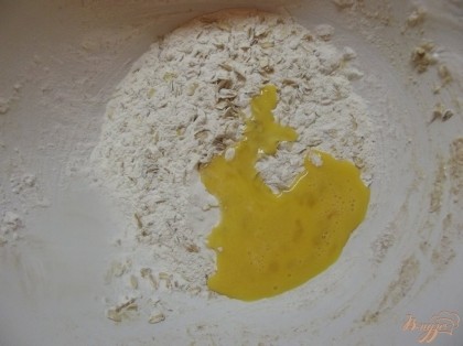 Отделите желтки от белков. Желтки положите к тесту. Масло сливочное растопите и добавьте следом. Перемешайте.