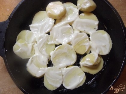 В форму для выпекания выложите картофель, сверху смажьте майонезом.