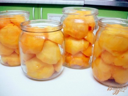 В чистые стерилизованные баночки складываем персики разрезом вниз. Из воды, сахара и лимонной кислоты варим сироп. Горячим сиропом заливаем персики.