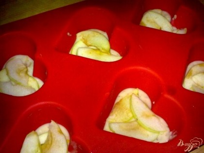 Половину теста выложить в формы для кексов, а затем выложить яблоко.