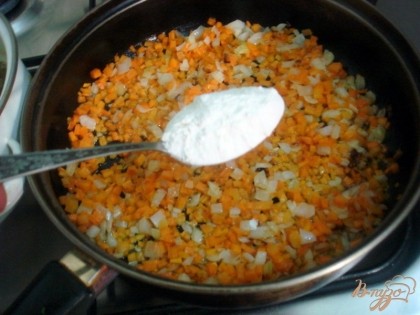 Когда морковь и лук станут мягкими, добавляем одну столовую ложку муки, которая послужит загустителем. Перемешаем.
