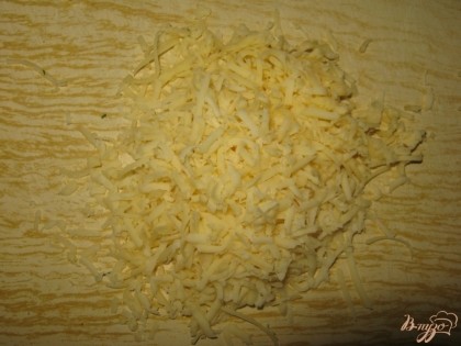 По гнезда в духовке на средней терке натираем твердый сыр.