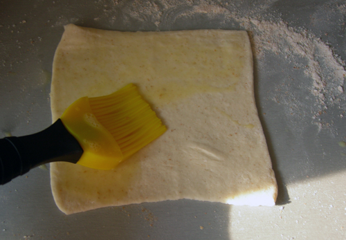 Тесто режем на квадратики и раскатываем каждый так, чтобы он сохранил квадратную форму, и в него можно было уложить кусочки тыквы. Смазываем тесто яйцом.<br>