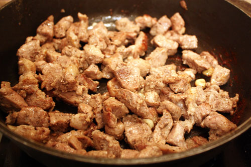 Мясо режем небольшими кусочками и обжариваем на сильном огне с оливковым маслом. Откладываем его в сторонку.