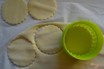 Из слоеного теста формочкой для печенья вырезать круги.