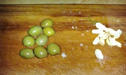 Арахис очистить и разделить каждый орешек на две половинки. Из оливок слить сок и каждую оливку разрезать пополам.