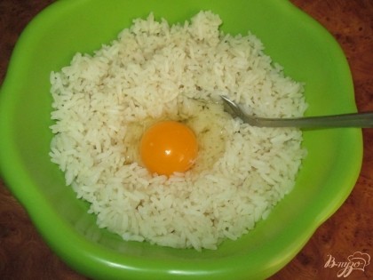 В готовый, отваренный рис, разбить куриные яйца и перемешать.