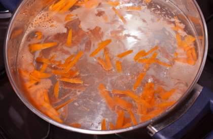 В кастрюлю налить 2 л воды, поставить на огонь. Когда вода закипит, высыпать оставшуюся половину нарезанной моркови.