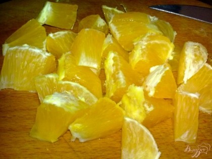 Апельсин вымыть, очистить и нарезать кубиками.