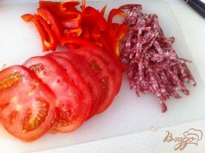 Нарезаем соломкой колбасу, перец и кружочками помидор.