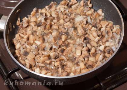 В лук выложить нарезанные шампиньоны, посолить, поперчить, и обжарить примерно минут десять, пока вода из грибов не выпарится.
