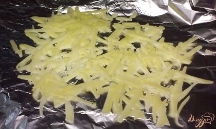 Сыр натереть на крупной терке. Половину сыра выложить на фольгу.