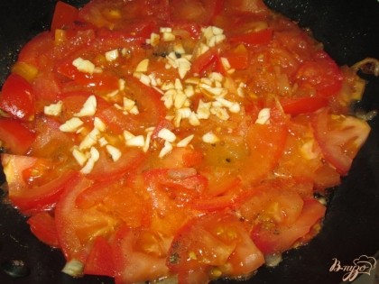 Во время жарки к помидорам добавить измельченный чеснок, черный молотый перец и соль.