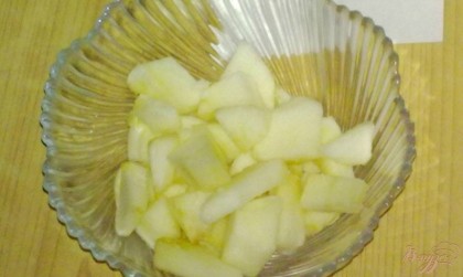 Яблоко вымыть, снять кожуру, удалить семечки и нарезать ломтиками. Сбрызнуть их лимонным соком. Выложить их в салатник или креманку.