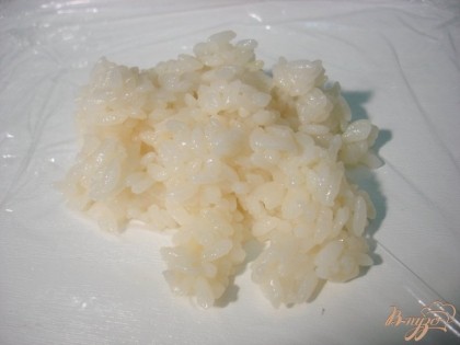 На пищевую плёнку выкладываем две столовые ложки рисовой каши.