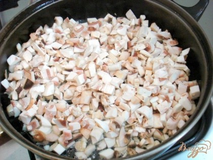 Разогреваем сковороду с двумя столовыми ложками растительного масла и обжариваем на них грибы.