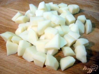 Картофель нарезаем кубиками и отправляем вариться в кастрюлю с водой. Добавляем туда оливковое масло и порезанные лисички.