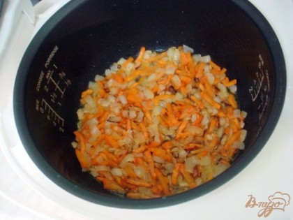 В чашу мультиварки налейте растительное масло, выложите лук и морковь. Включите режим *Тушение* на 20 минут. Время от времени перемешивайте, чтобы не подгорело.