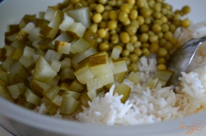 В салатник выложить отварной рис, маринованный огурчик и зеленый горошек.
