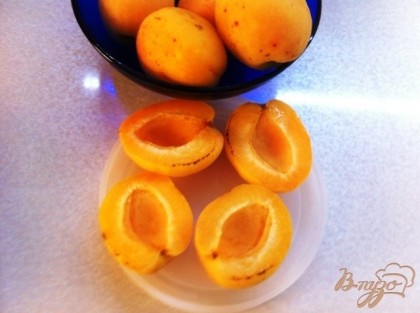 Разрезаем абрикосы по полам и вынимаем косточки.