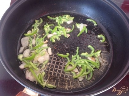 На разогретую сковороду вливаем растительное масло, бросаем лук и перец, жарим пару минут.