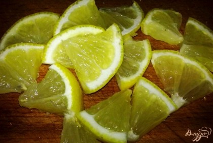 Лимон тщательно моем, вытираем насухо и нарезаем кружочками. Затем кружочки разрезаем на четыре или шесть частей.