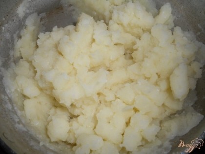 Затем разминаем картофель в пюре при помощи толкушки, одновременно перемешивая его с молоком.