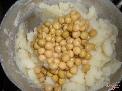 К получившемуся картофельному пюре добавляем консервированный зеленый горошек (без жидкости из банки). Перемешиваем пюре с горошком.