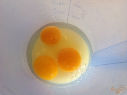 В отдельную емкость всыпаем сахар и добавляем яйца.