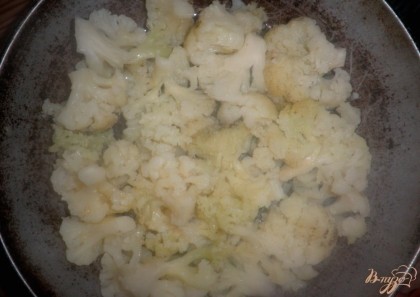 Форму для выпекания (сковороду) смазать подсолнечным маслом, выложить соцветия капусты