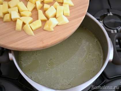 Из кастрюли вынуть окорочок и луковицу (её выбросить). Бульон посолить, поперчить, добавить картофель.