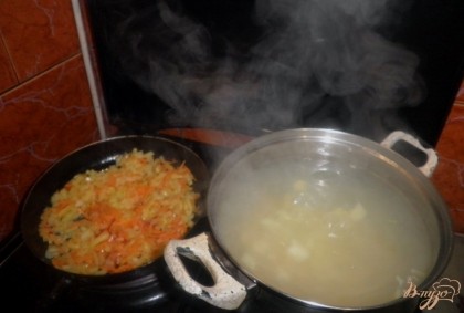 Закипятить в кастрюле 3 литра воды, бросить порезанный картофель и варить около 20 минут. В это же время на подсолнечном масле пожарить измельченную луковицу, натертую морковь и порезанный соломкой сладкий перец (10 минут)