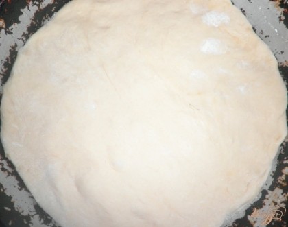 Далее смазать круглую форму маслом и выложить на нее тесто, равномерно расправить